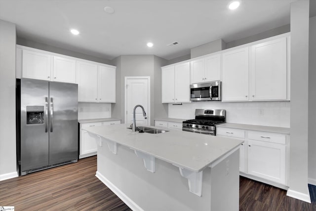 kitchen with stainless steel appliances, white cabinets, dark wood-type flooring, and a sink