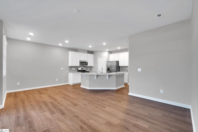 kitchen featuring tasteful backsplash, visible vents, appliances with stainless steel finishes, a sink, and light wood-type flooring