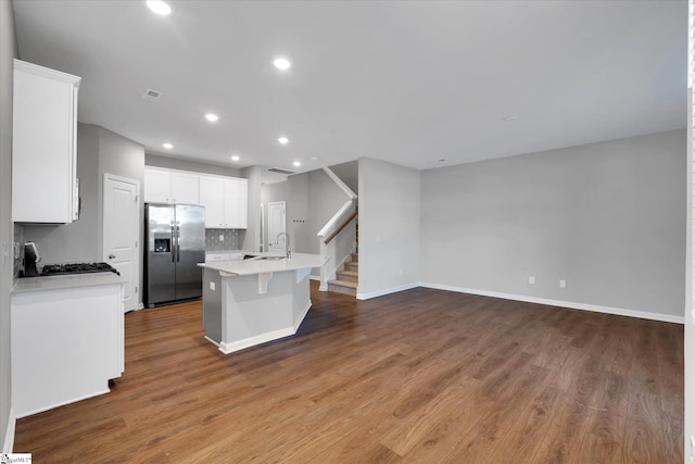 kitchen featuring white cabinetry, light countertops, wood finished floors, and stainless steel fridge with ice dispenser