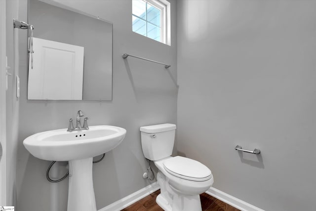 bathroom with baseboards, toilet, and wood finished floors