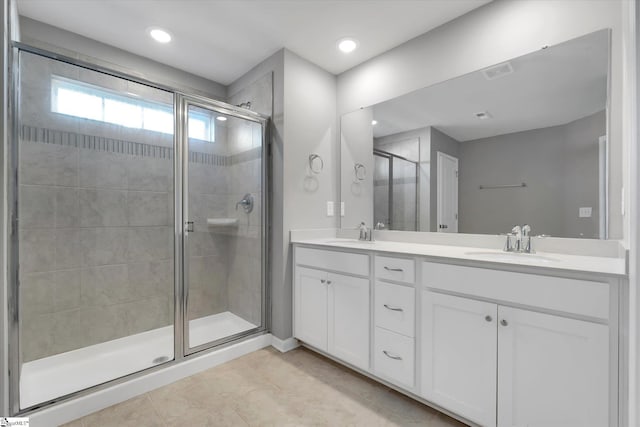 full bathroom with a stall shower, visible vents, a sink, and double vanity