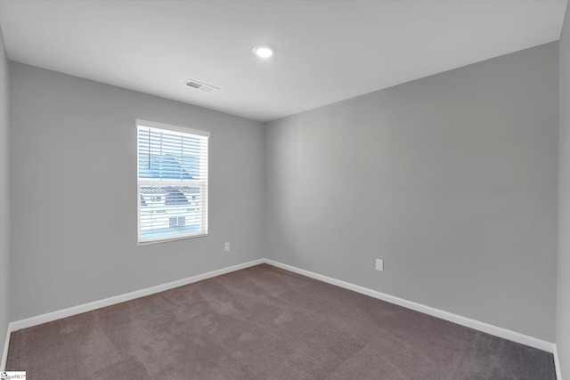 unfurnished room featuring recessed lighting, visible vents, dark carpet, and baseboards