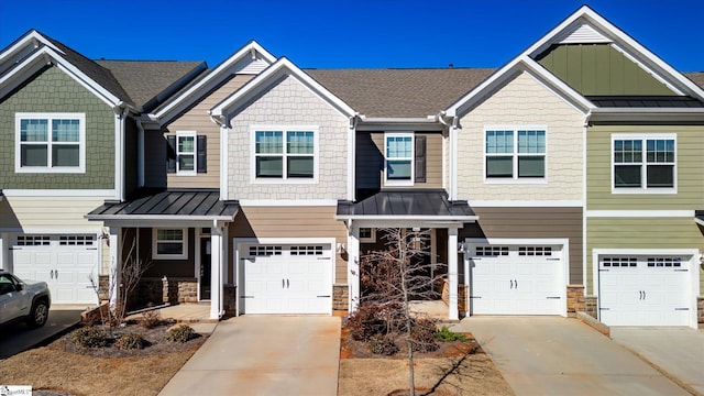 multi unit property featuring board and batten siding, a standing seam roof, and driveway