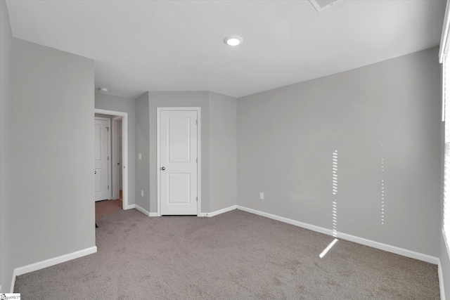 carpeted empty room featuring baseboards