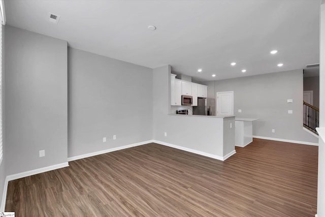 kitchen with stainless steel appliances, recessed lighting, white cabinets, wood finished floors, and baseboards