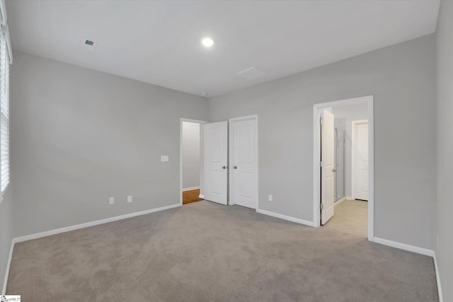 unfurnished bedroom featuring carpet floors, visible vents, and baseboards