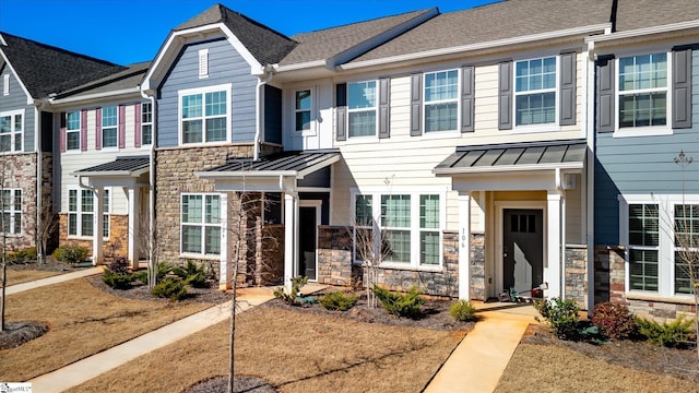 townhome / multi-family property featuring stone siding, roof with shingles, metal roof, and a standing seam roof