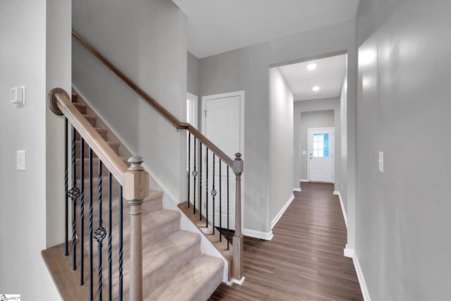 stairs with wood finished floors and baseboards