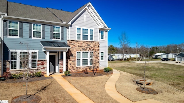 view of front facade featuring metal roof, stone siding, a standing seam roof, and a front yard