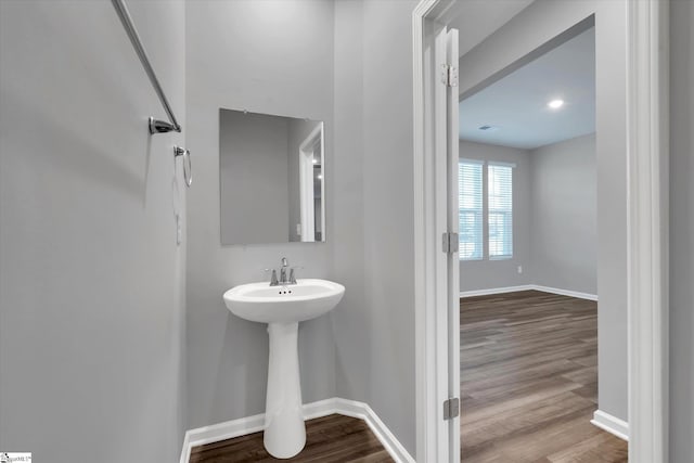 bathroom with a sink, baseboards, and wood finished floors