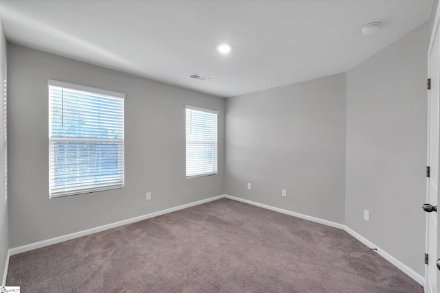 carpeted empty room with visible vents and baseboards