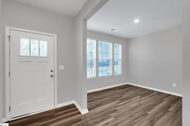 foyer entrance featuring a healthy amount of sunlight, visible vents, baseboards, and dark wood finished floors