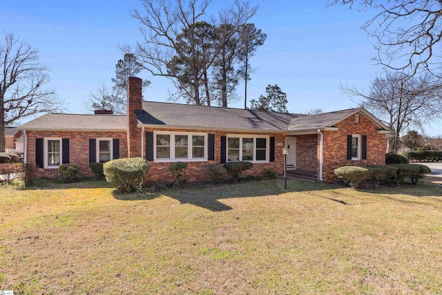 single story home featuring a front yard, a chimney, and brick siding