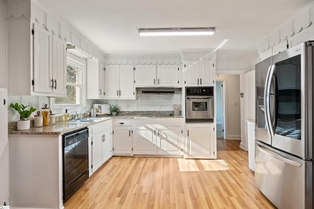 kitchen with black appliances, a sink, light wood-style flooring, and white cabinets