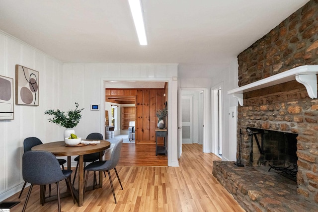 dining area with visible vents, a fireplace, and light wood-style flooring