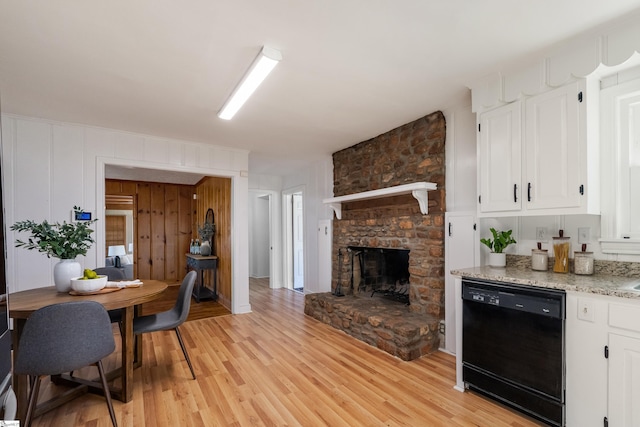 living area with a stone fireplace and light wood-style floors