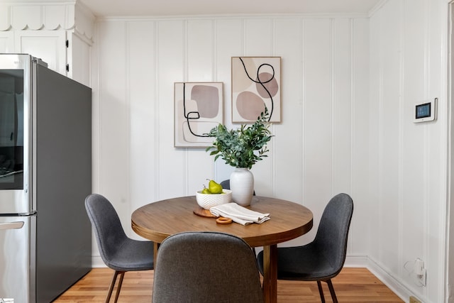 dining room with light wood-type flooring and a decorative wall