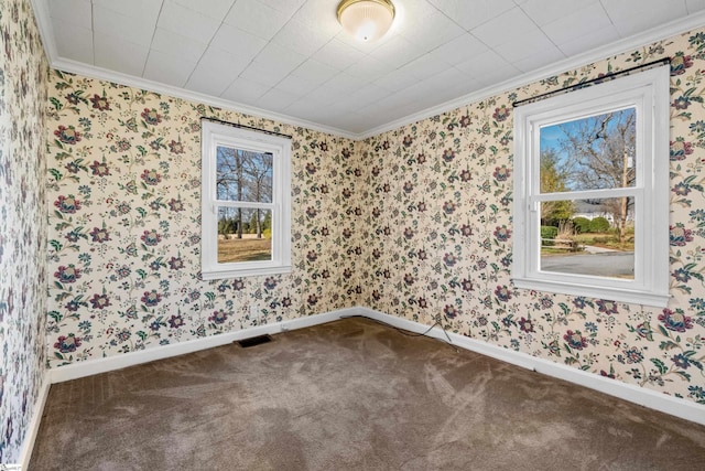 spare room featuring baseboards, carpet, visible vents, and wallpapered walls