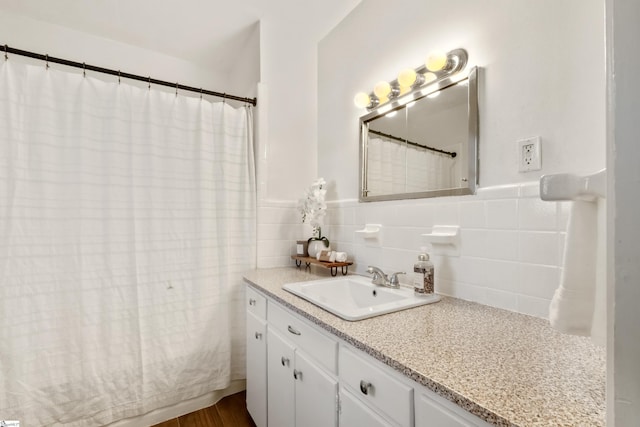 full bathroom featuring a wainscoted wall, tile walls, and vanity