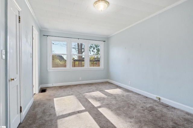 carpeted spare room with baseboards, visible vents, and crown molding