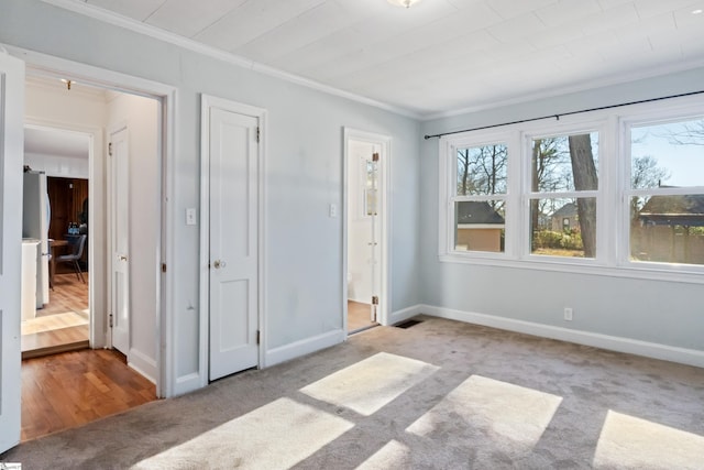 unfurnished bedroom featuring baseboards, ornamental molding, and carpet flooring