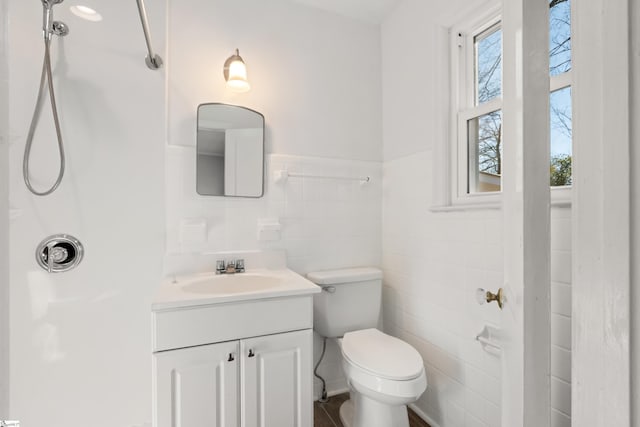 bathroom with walk in shower, tile walls, toilet, and vanity