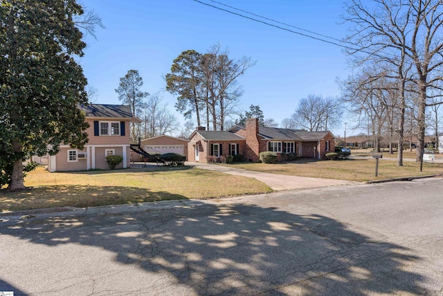 view of front of property featuring a garage, brick siding, driveway, a chimney, and a front yard