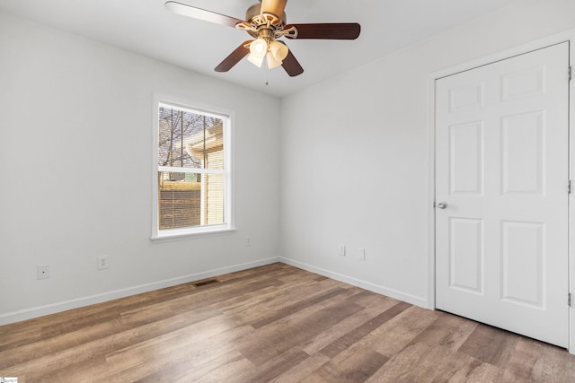 empty room with visible vents, ceiling fan, light wood-style flooring, and baseboards