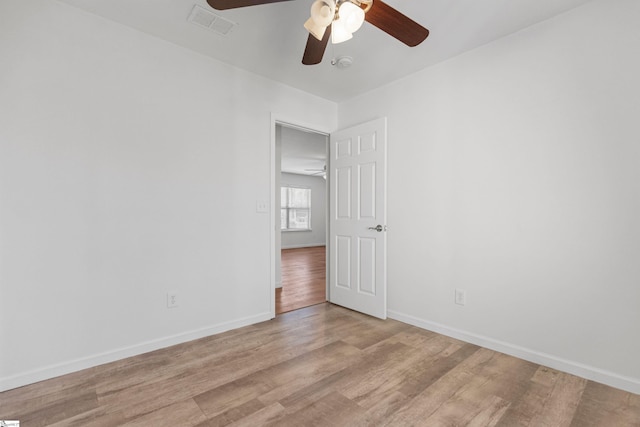 unfurnished room with light wood finished floors, baseboards, and visible vents