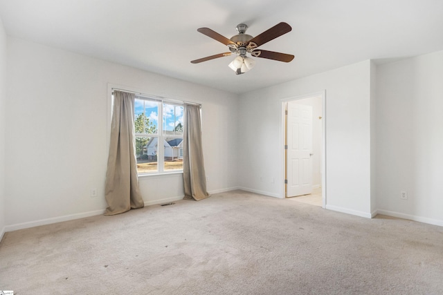 empty room featuring carpet, visible vents, baseboards, and ceiling fan