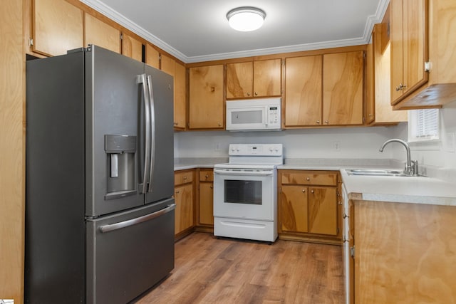 kitchen featuring white appliances, wood finished floors, light countertops, crown molding, and a sink