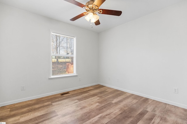 spare room with light wood-style floors, baseboards, visible vents, and ceiling fan