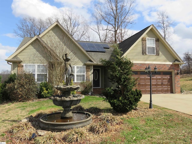 view of front of property with driveway, brick siding, and roof mounted solar panels