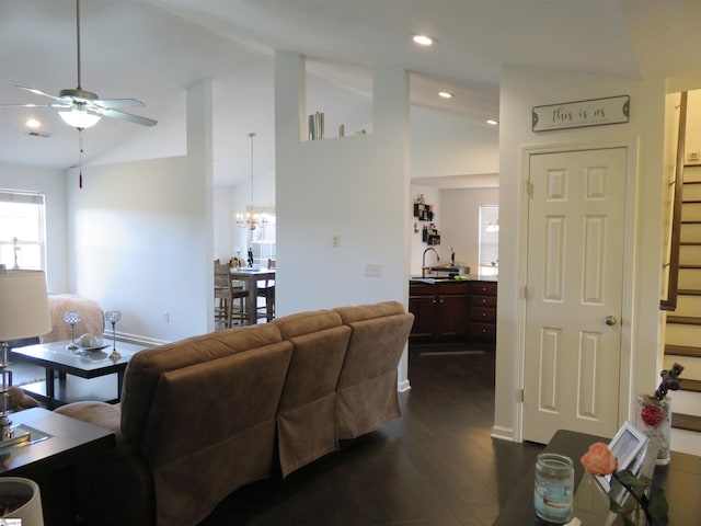 living area with dark wood finished floors, recessed lighting, vaulted ceiling, baseboards, and ceiling fan with notable chandelier