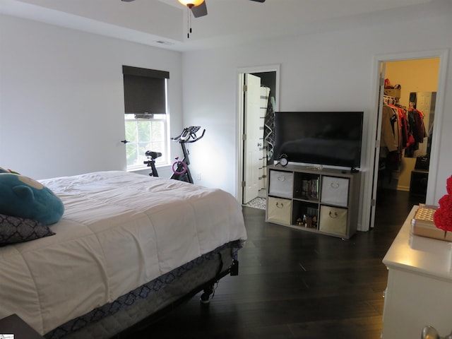 bedroom featuring visible vents, dark wood finished floors, a spacious closet, and ceiling fan