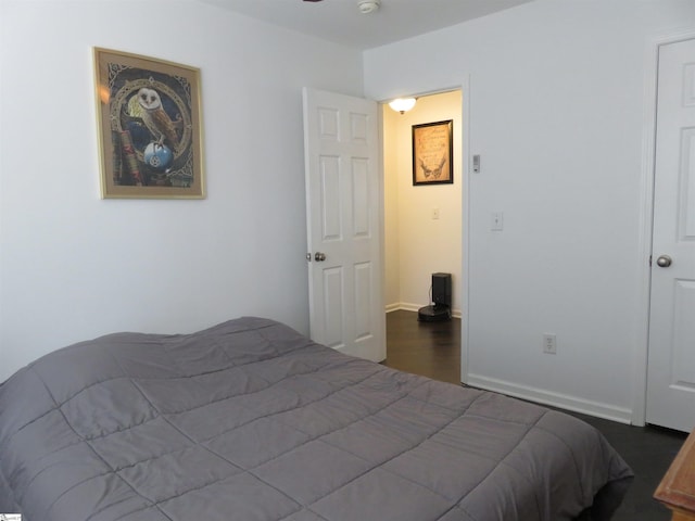 bedroom featuring dark wood-style floors and baseboards