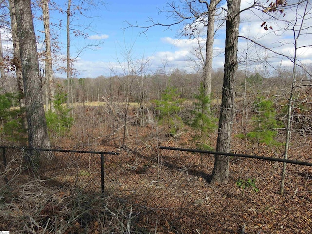 exterior space with a forest view and fence