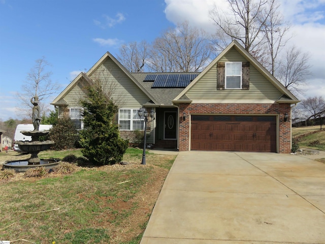 view of front of home featuring driveway, brick siding, and roof mounted solar panels