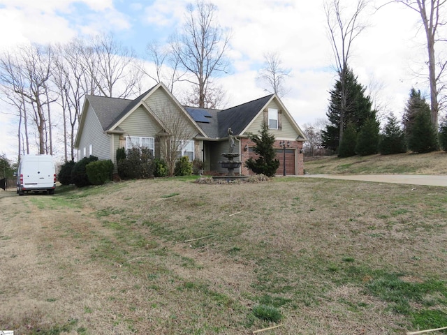 view of front of property featuring a garage, a front lawn, and brick siding