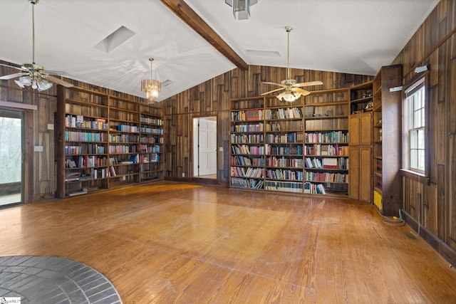 unfurnished room featuring bookshelves, built in shelves, and wooden walls