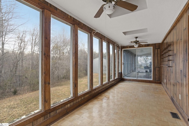 unfurnished sunroom featuring visible vents and ceiling fan