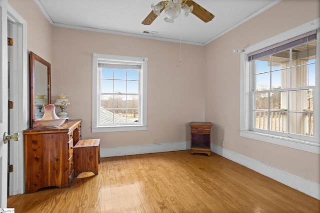 interior space featuring a wealth of natural light, visible vents, and crown molding