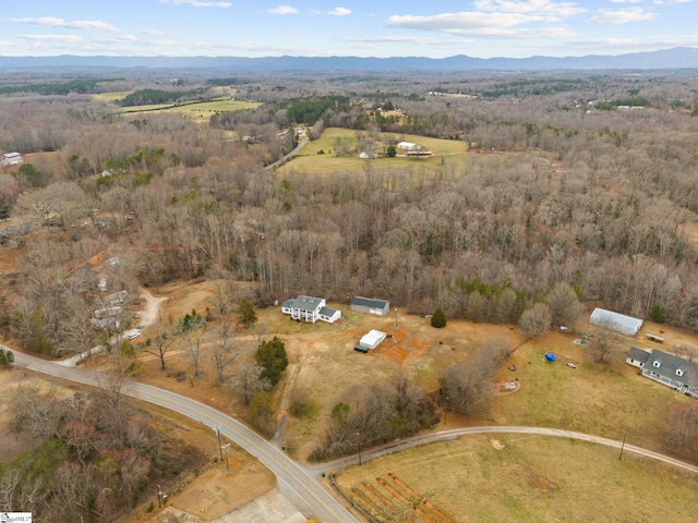 aerial view featuring a wooded view and a mountain view