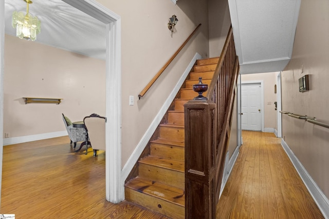 stairway featuring wood finished floors and baseboards