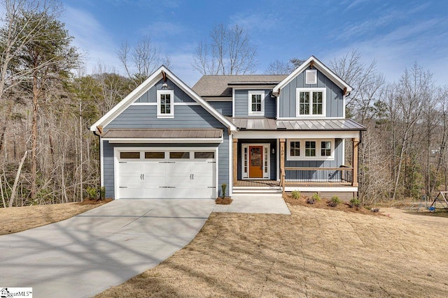 view of front of property featuring a porch, board and batten siding, a standing seam roof, a garage, and driveway