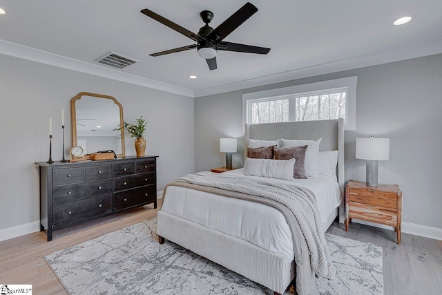 bedroom featuring baseboards, crown molding, visible vents, and wood finished floors