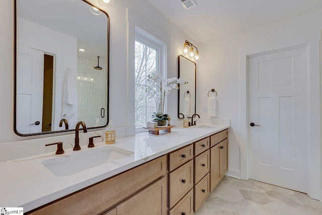 full bath featuring double vanity, a stall shower, visible vents, and a sink