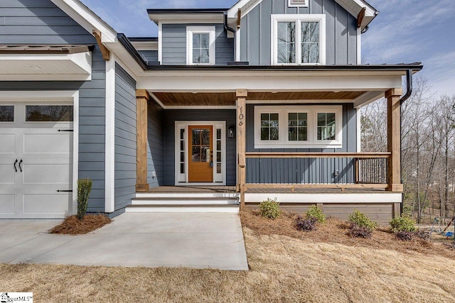 doorway to property featuring board and batten siding, a porch, and an attached garage