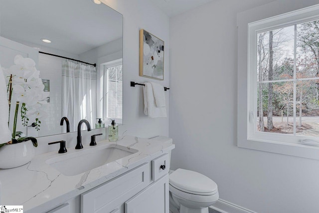 full bathroom featuring a healthy amount of sunlight, toilet, a shower with shower curtain, and vanity