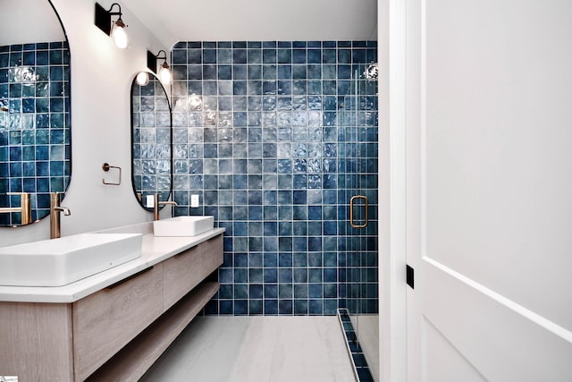 full bathroom with tile walls, double vanity, a stall shower, a sink, and tile patterned flooring